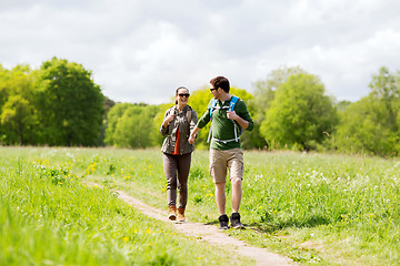 Image showing happy couple with backpacks hiking outdoors