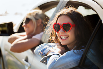 Image showing happy teenage girls or women in car at seaside