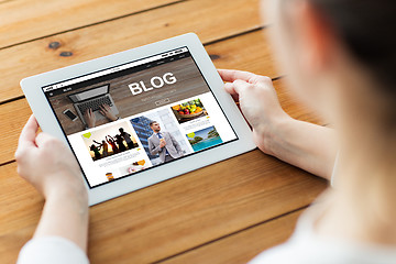 Image showing close up of woman with tablet pc on wooden table