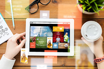 Image showing close up of woman with tablet pc on wooden table