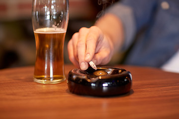 Image showing close up of man smoking cigarette at bar