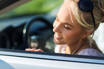 Image showing happy teenage girl or young woman in car