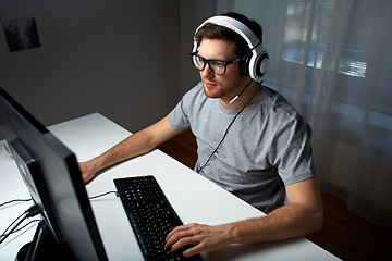 Image showing man in headset playing computer video game at home