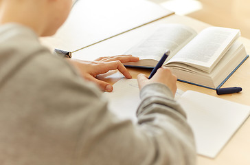 Image showing close up of student writing to notebook at school