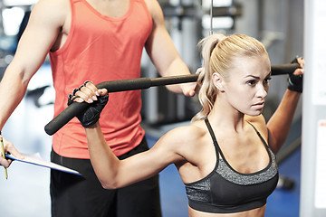 Image showing man and woman flexing muscles on gym machine