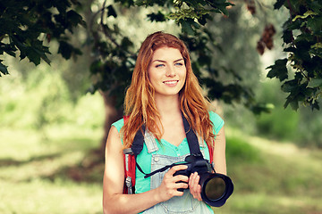 Image showing happy woman with backpack and camera outdoors