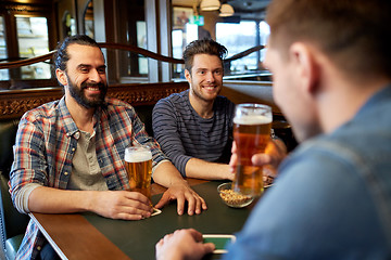 Image showing happy male friends drinking beer at bar or pub