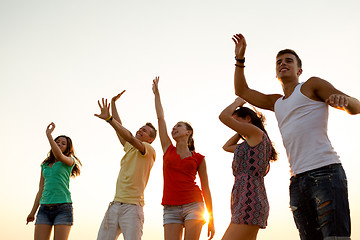 Image showing smiling friends dancing on summer beach