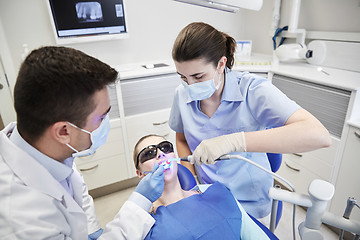 Image showing dentists treating male patient teeth at clinic