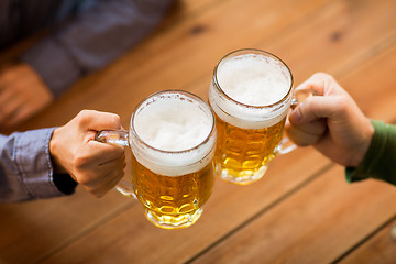 Image showing close up of hands with beer mugs at bar or pub