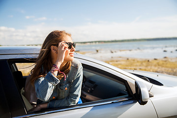 Image showing happy teenage girl or young woman in car