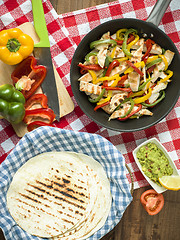 Image showing delicious wrap tortilla with spicy chicken vegetables guacamole