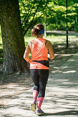 Image showing Young female jogger in park