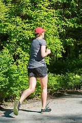 Image showing Young female jogger in park
