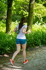 Image showing Young female jogger in park