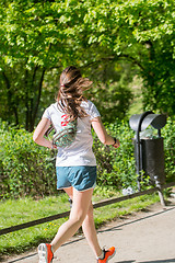 Image showing Young female jogger in park