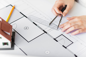 Image showing close up of hands with compass measuring blueprint