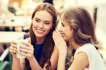 Image showing young women drinking coffee and talking at cafe