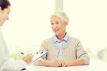 Image showing doctor with clipboard and senior woman at hospital