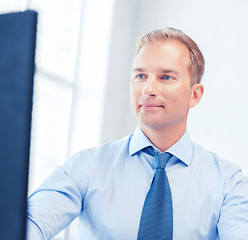 Image showing businessman with calculator, computer and papers