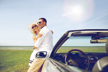 Image showing happy couple hugging near cabriolet car at sea