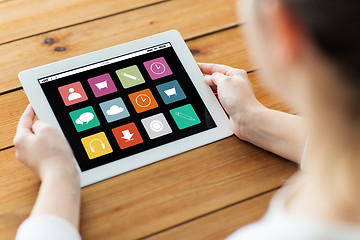 Image showing close up of woman with tablet pc on wooden table