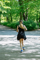 Image showing Young female jogger with headphones