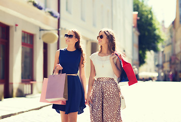 Image showing happy women with shopping bags walking in city 