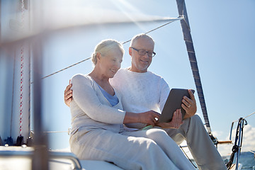 Image showing senior couple with tablet pc on sail boat or yacht