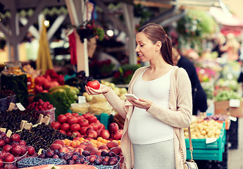 Image showing pregnant woman with smartphone at street market