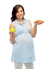 Image showing happy pregnant woman with apple and croissant