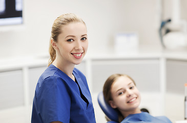 Image showing happy female dentist with patient girl at clinic