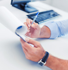 Image showing businessman working and signing papers