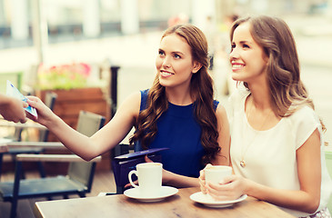 Image showing women paying money to waiter for coffee at cafe