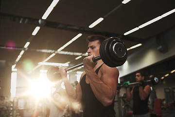 Image showing young men flexing muscles with barbells in gym