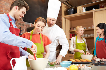 Image showing happy friends and chef cook baking in kitchen