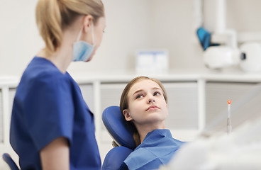 Image showing happy female dentist with patient girl at clinic