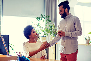 Image showing happy man bringing coffee to woman in office