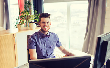 Image showing happy creative male office worker with computer