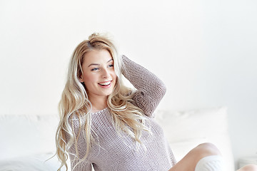 Image showing happy young woman stretching in bed at home