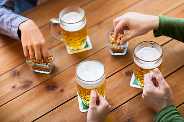 Image showing close up of hands with beer mugs at bar or pub