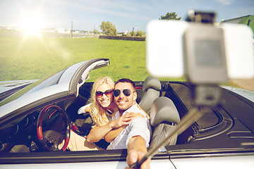 Image showing happy couple in car taking selfie with smartphone