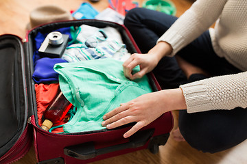 Image showing close up of woman packing travel bag for vacation