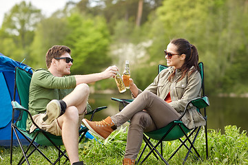 Image showing happy couple clinking drinks at campsite tent