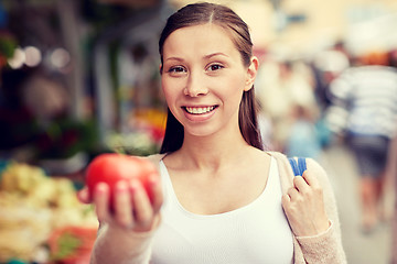 Image showing happy woman holding tomato at street market