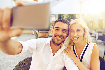 Image showing couple taking selfie with smatphone at restaurant