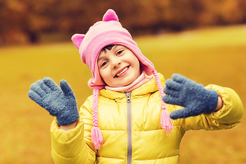 Image showing happy beautiful little girl waving hands outdoors