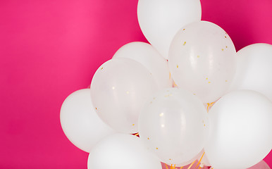 Image showing close up of white helium balloons over pink