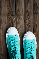 Image showing blue sneakers on wooden surface