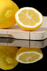 Image showing lemon on wood table with black background